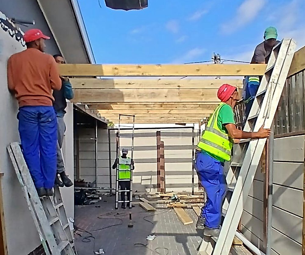 Team fitting timber beams for a new carport