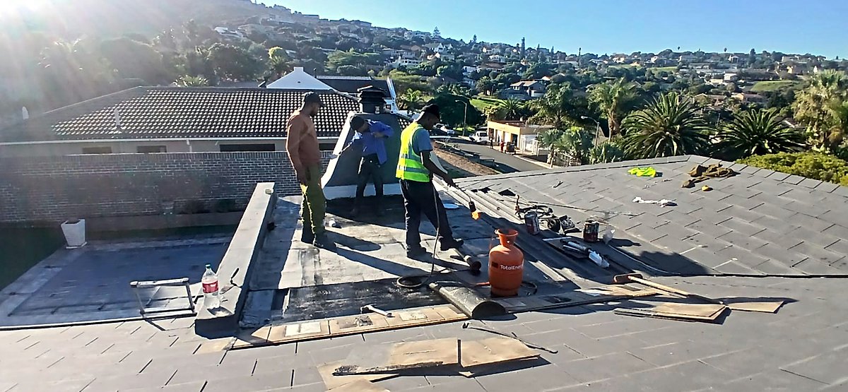 Torch-on waterproofing being applied to a flat roof section